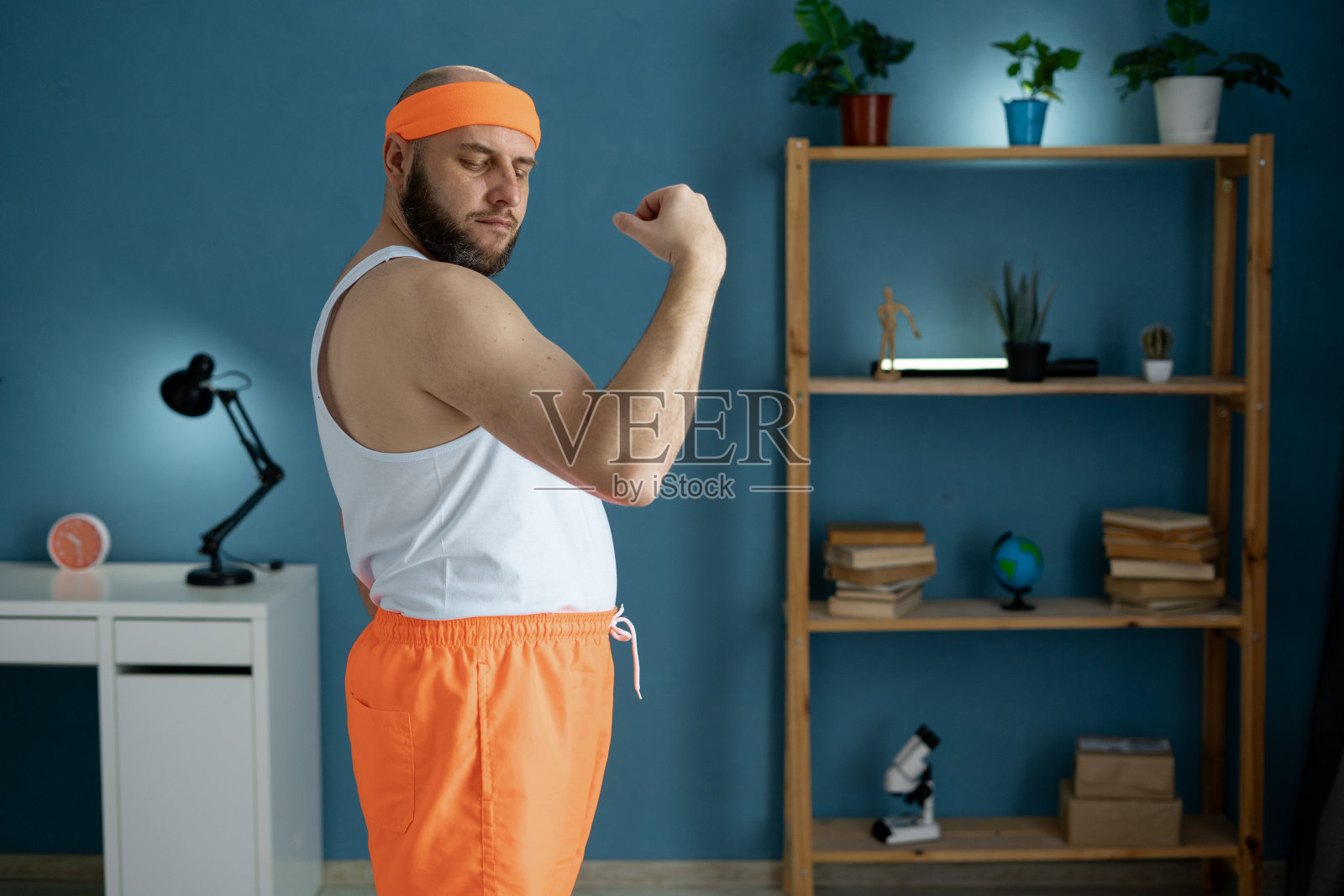 男子在家锻炼肱二头肌，展示肌肉的成长和健康。照片摄影图片