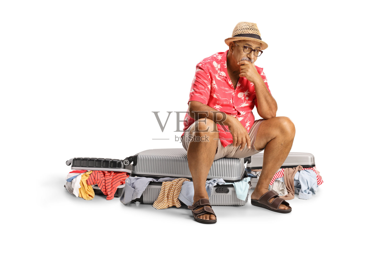 悲伤的中年男游客坐在装满凌乱衣物的行李箱上照片摄影图片