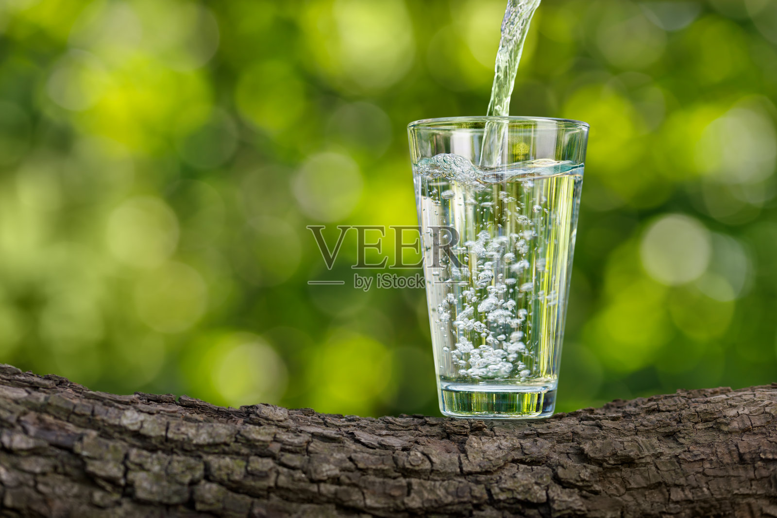水倒进玻璃原木与绿色自然背景照片摄影图片