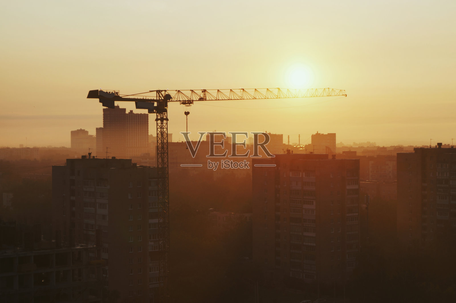 建筑起重机上方的箭头指向太阳照片摄影图片