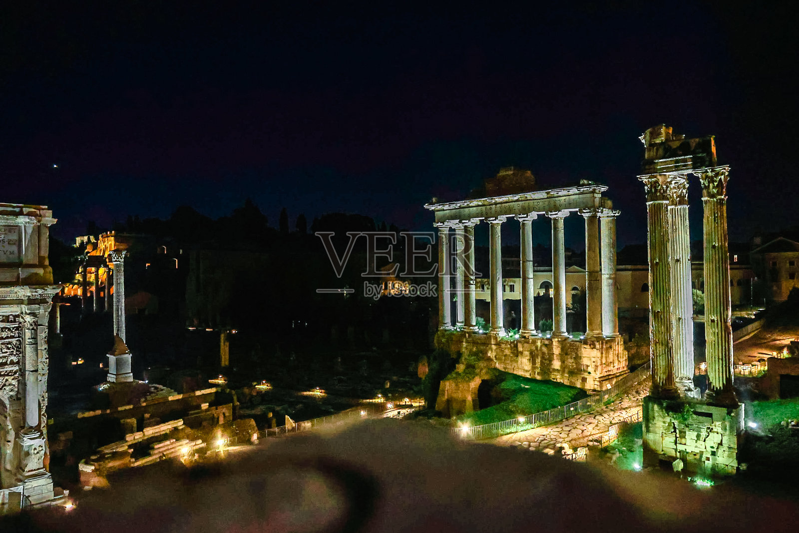 罗马广场，夜晚灯火通明。古罗马的建筑。从卡比托利欧山上的土星神庙，塞普提米乌斯·塞维鲁的凯旋门，意大利照片摄影图片