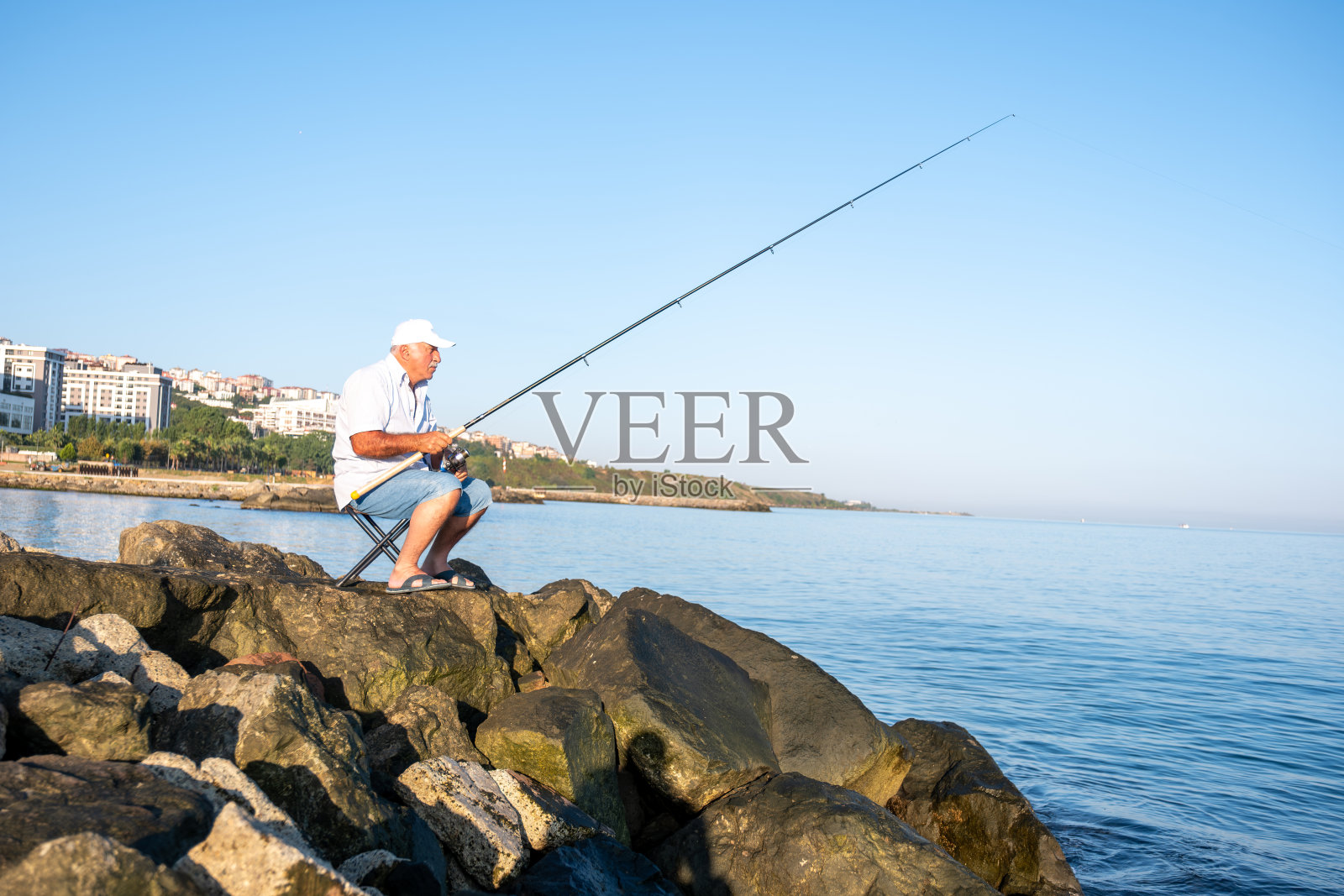 手持钓鱼竿的年长渔民肖像照片摄影图片