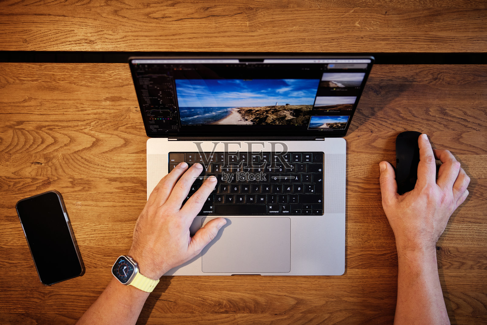 一名男子在桌子上使用笔记本电脑照片摄影图片