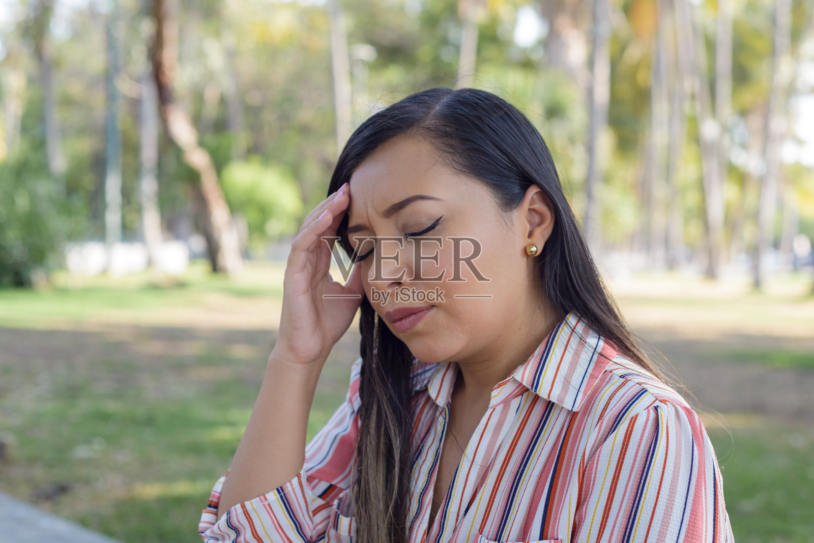 户外肖像的女人头痛的表情。偏头痛。照片摄影图片