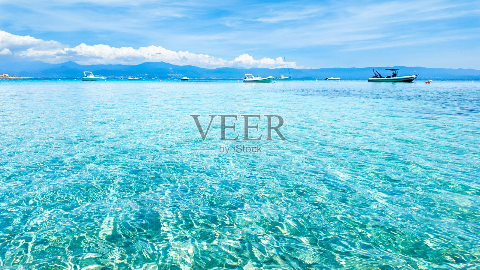 广阔的蓝绿色水域与船只在远处，马里内拉海滩，科西嘉岛。照片摄影图片