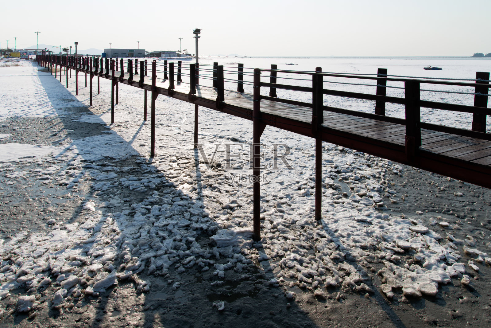 白雪覆盖的海边的木桥照片摄影图片