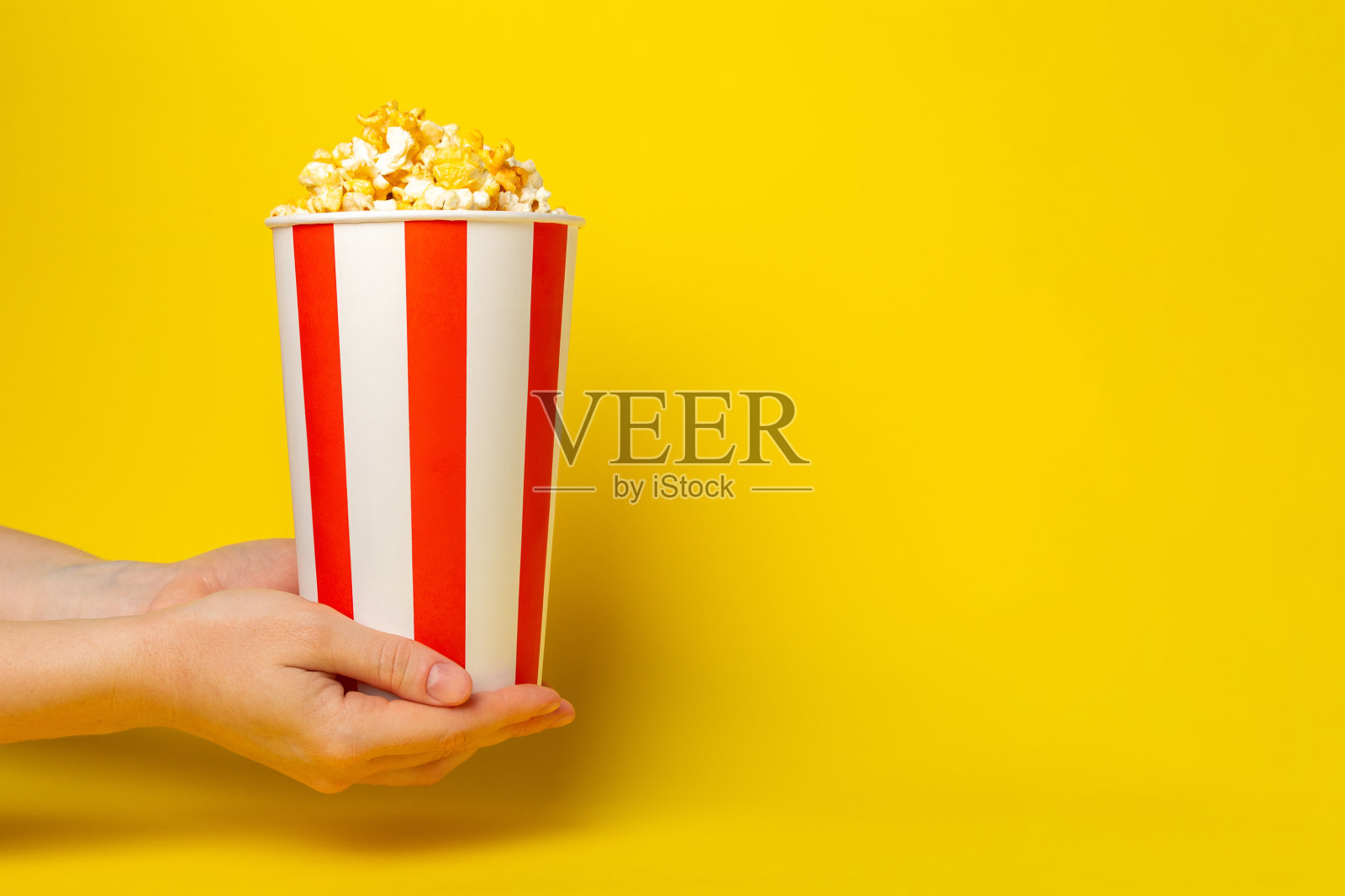 背景是美味的爆米花。电影院和娱乐的概念。有爆米花的电影之夜。奶酪和焦糖爆米花。美味的开胃菜，小吃。放文字的地方。副本的空间。横幅照片摄影图片