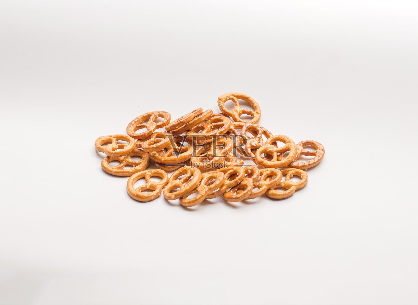 椒盐卷饼散落在白色的背景上。照片摄影图片