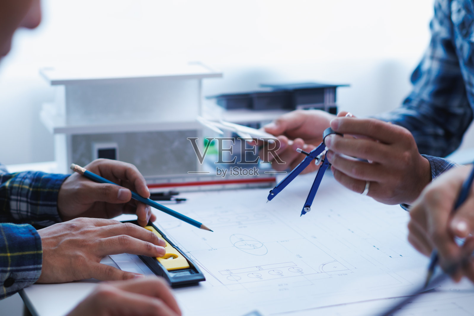 一个由工程师和建筑师组成的团队讨论房屋规划设计并估算建筑价格以适应建筑预算。与工程师和建筑师团队一起检查蓝图和文件照片摄影图片