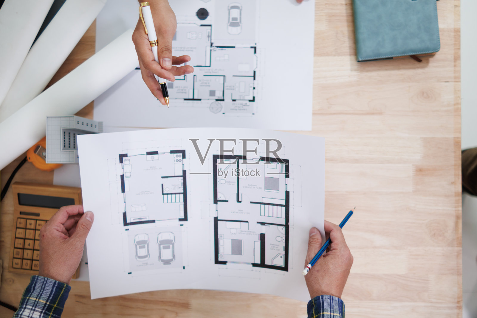 一个由工程师和建筑师组成的团队讨论房屋规划设计并估算建筑价格以适应建筑预算。与工程师和建筑师团队一起检查蓝图和文件照片摄影图片