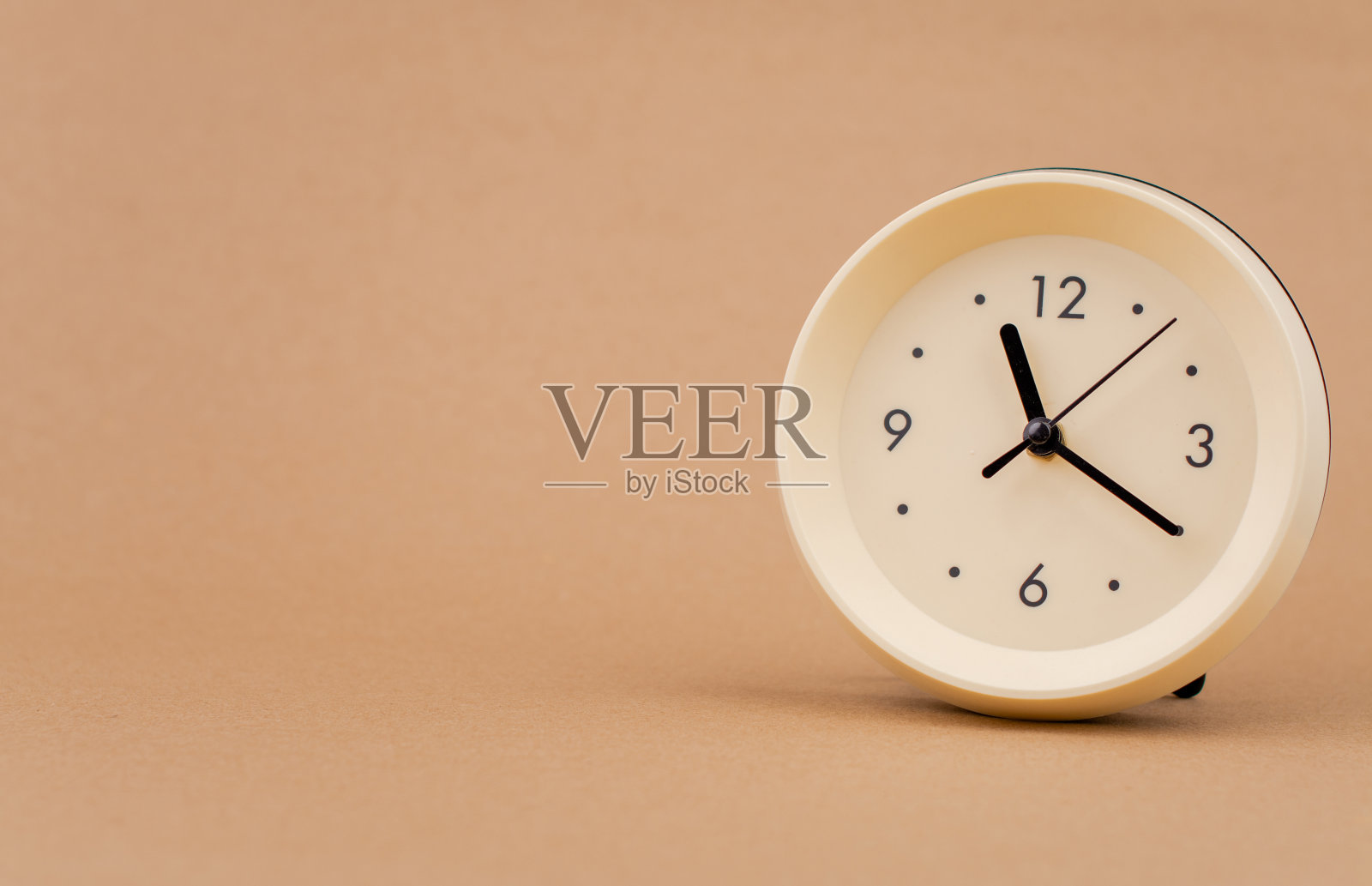 闹钟摄影在浅棕色背景工作室时间和生活和工作的概念照片摄影图片