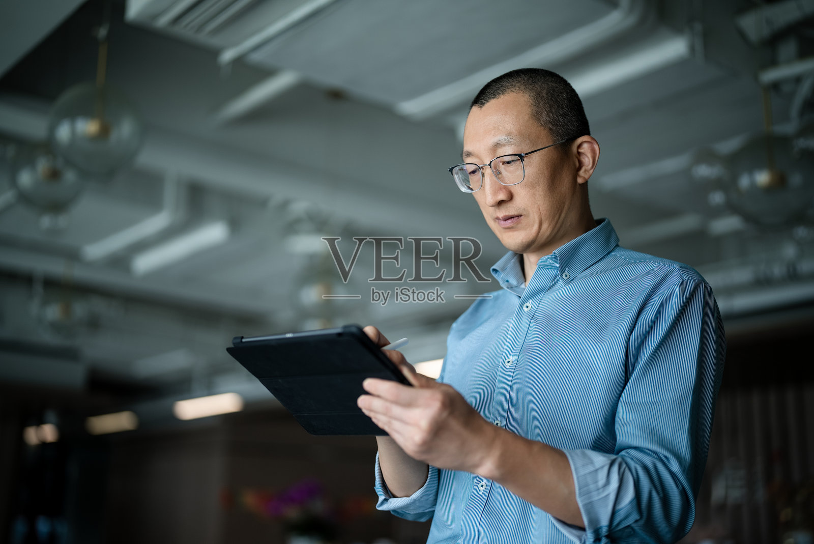 中年商务人士在办公场所使用平板电脑照片摄影图片