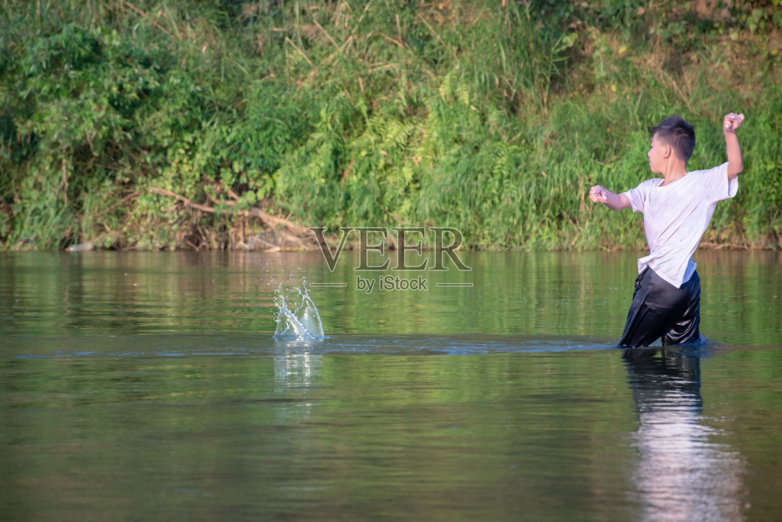 亚洲男孩在河里玩耍照片摄影图片