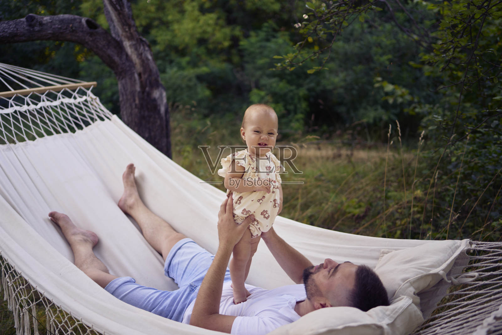 爸爸和他的小女儿在吊床上玩耍照片摄影图片