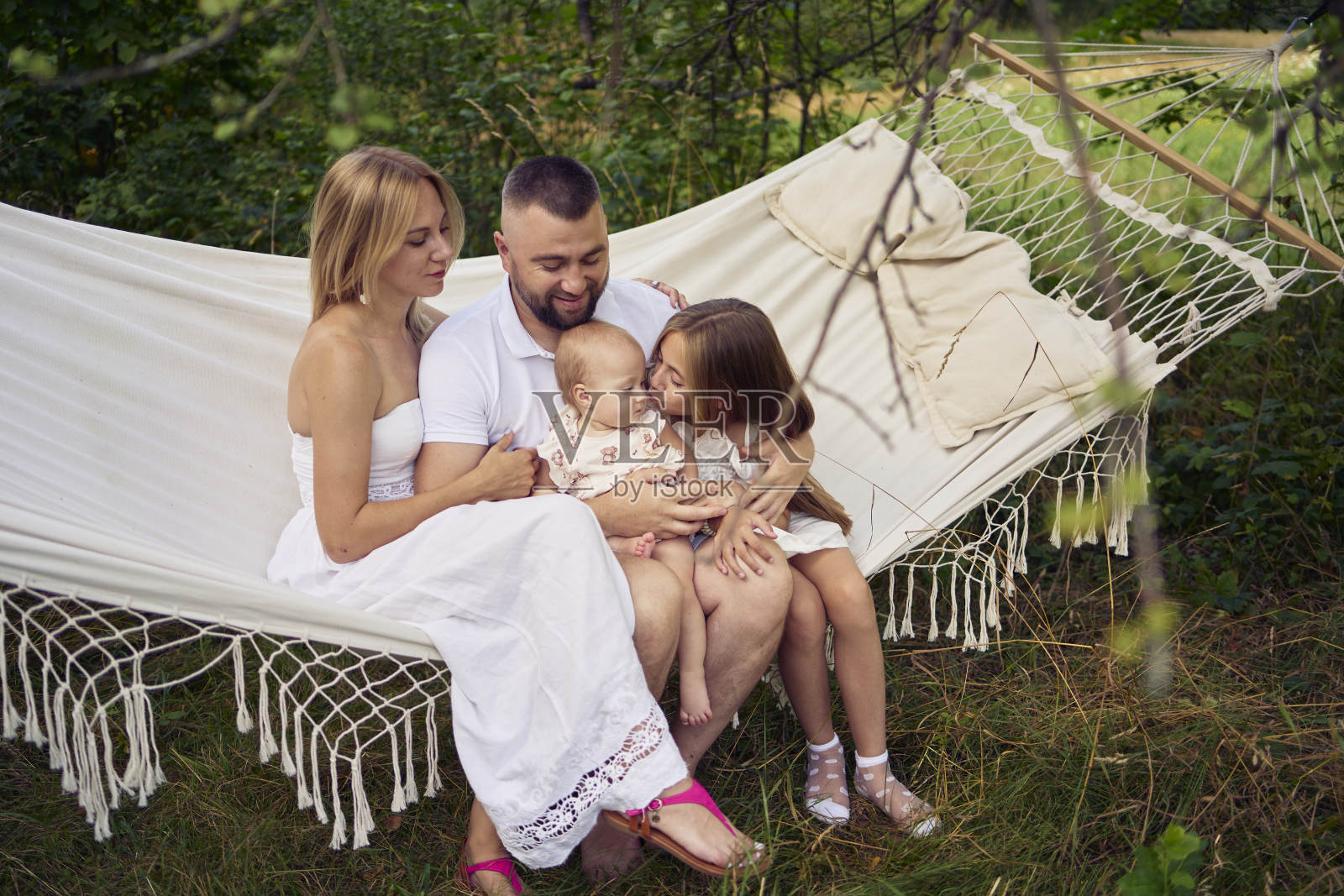 家人妈妈爸爸妹妹十几岁的孩子躺在吊床上照片摄影图片