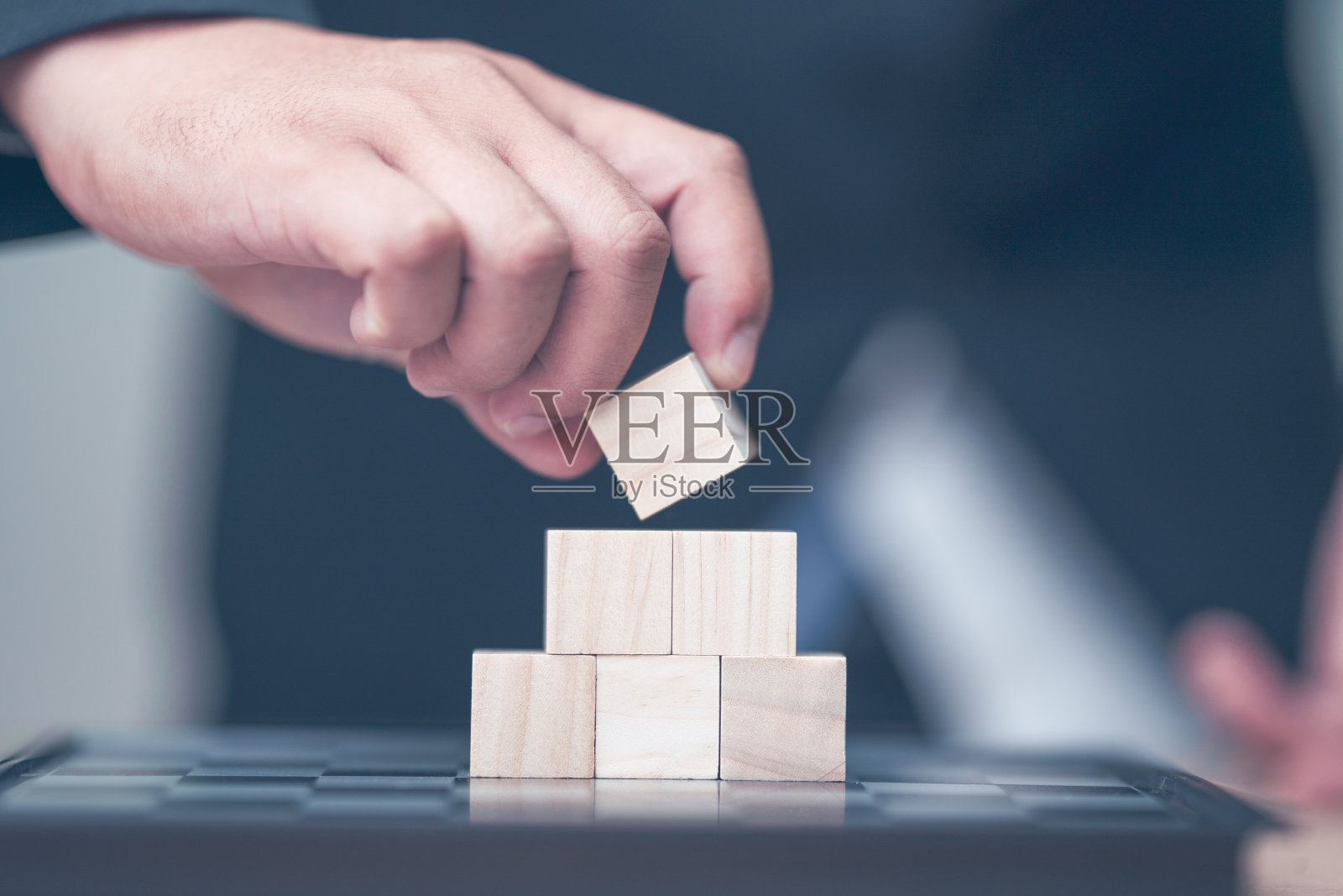 商人在桌子上堆砌木块的中景照片摄影图片