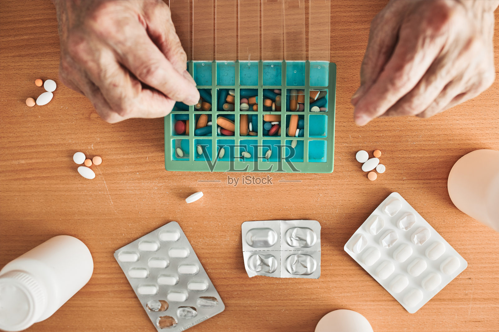 老人把他的药物整理成药丸分配器。老人从盒子里拿药片照片摄影图片