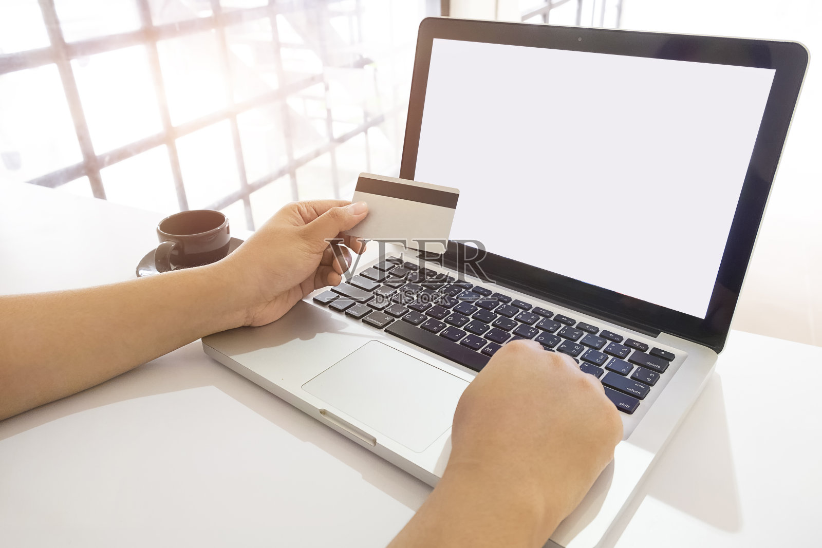 女性在餐桌上使用笔记本电脑时进行卡片支付的裁剪手照片摄影图片