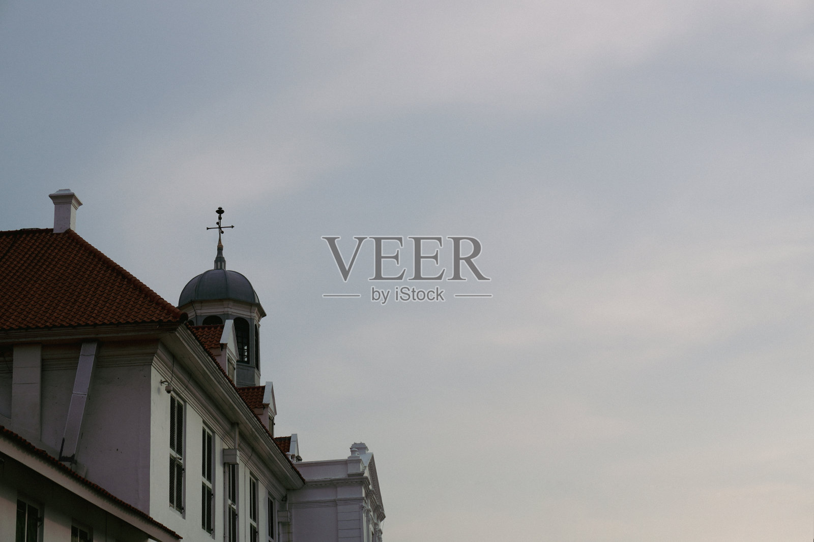 古老的塔顶着风向标，映衬着美丽的蓝天。雅加达旧城政府办公室的屋顶照片摄影图片