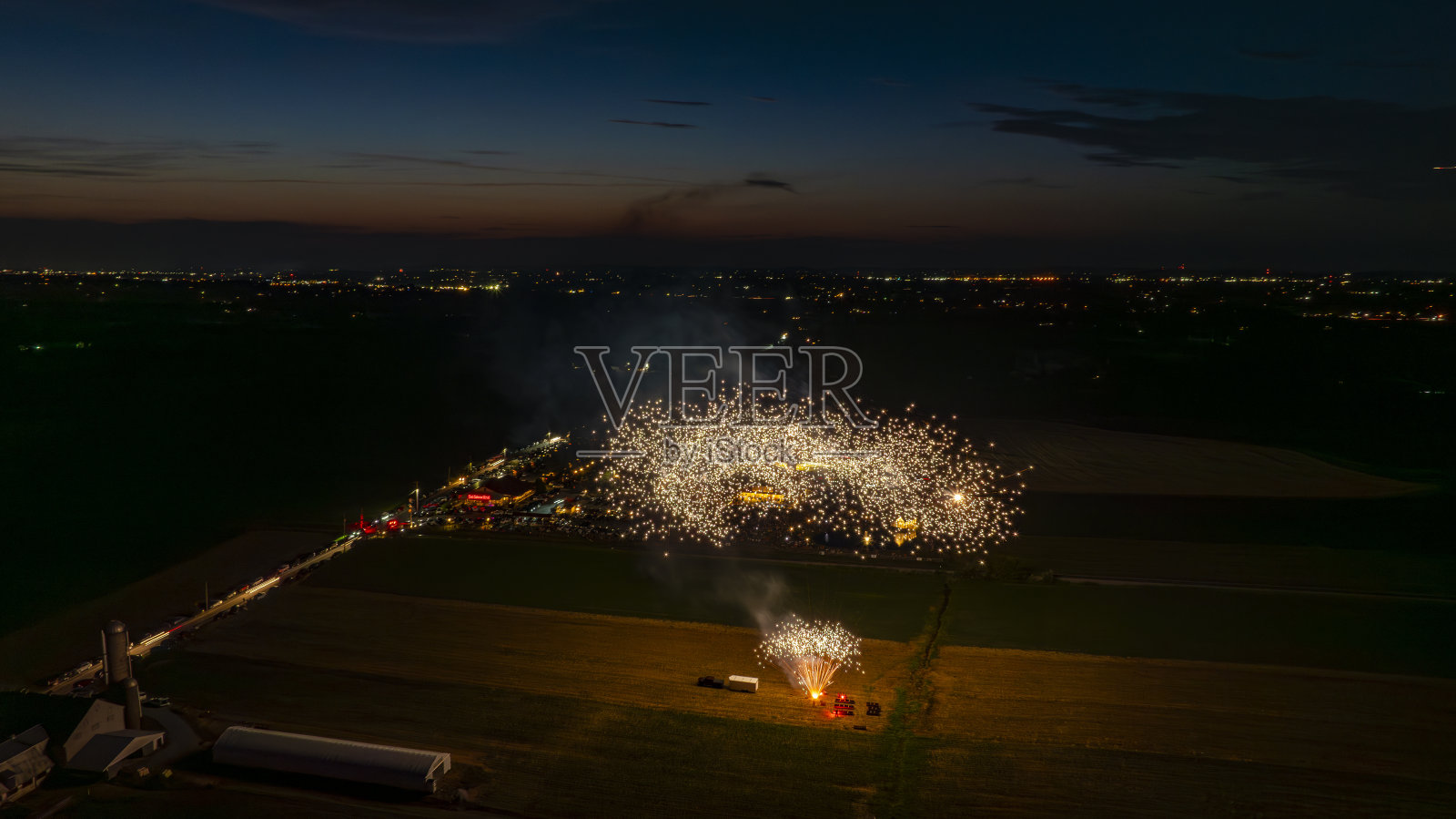 金色的烟花在夜空中形成一片浓密的闪闪发光的云，照亮了一个聚会照片摄影图片