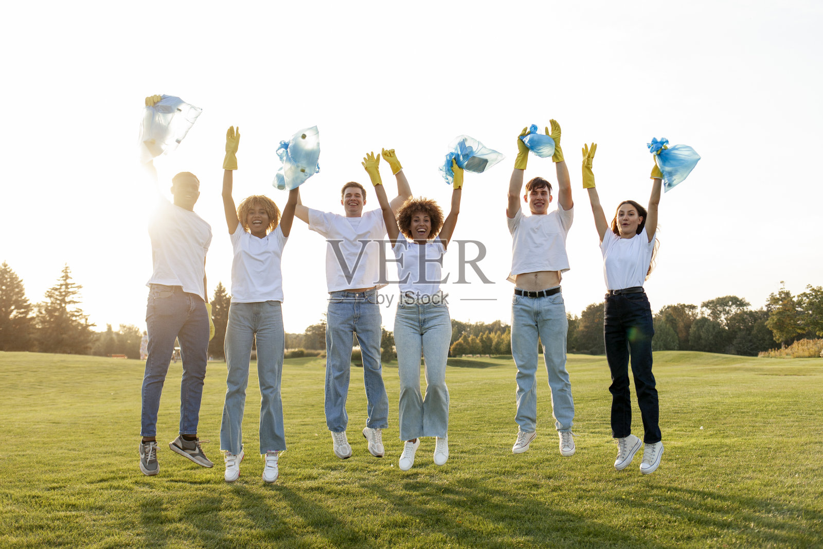 多种族志愿者戴着手套，带着垃圾袋在公园里收集垃圾和塑料照片摄影图片