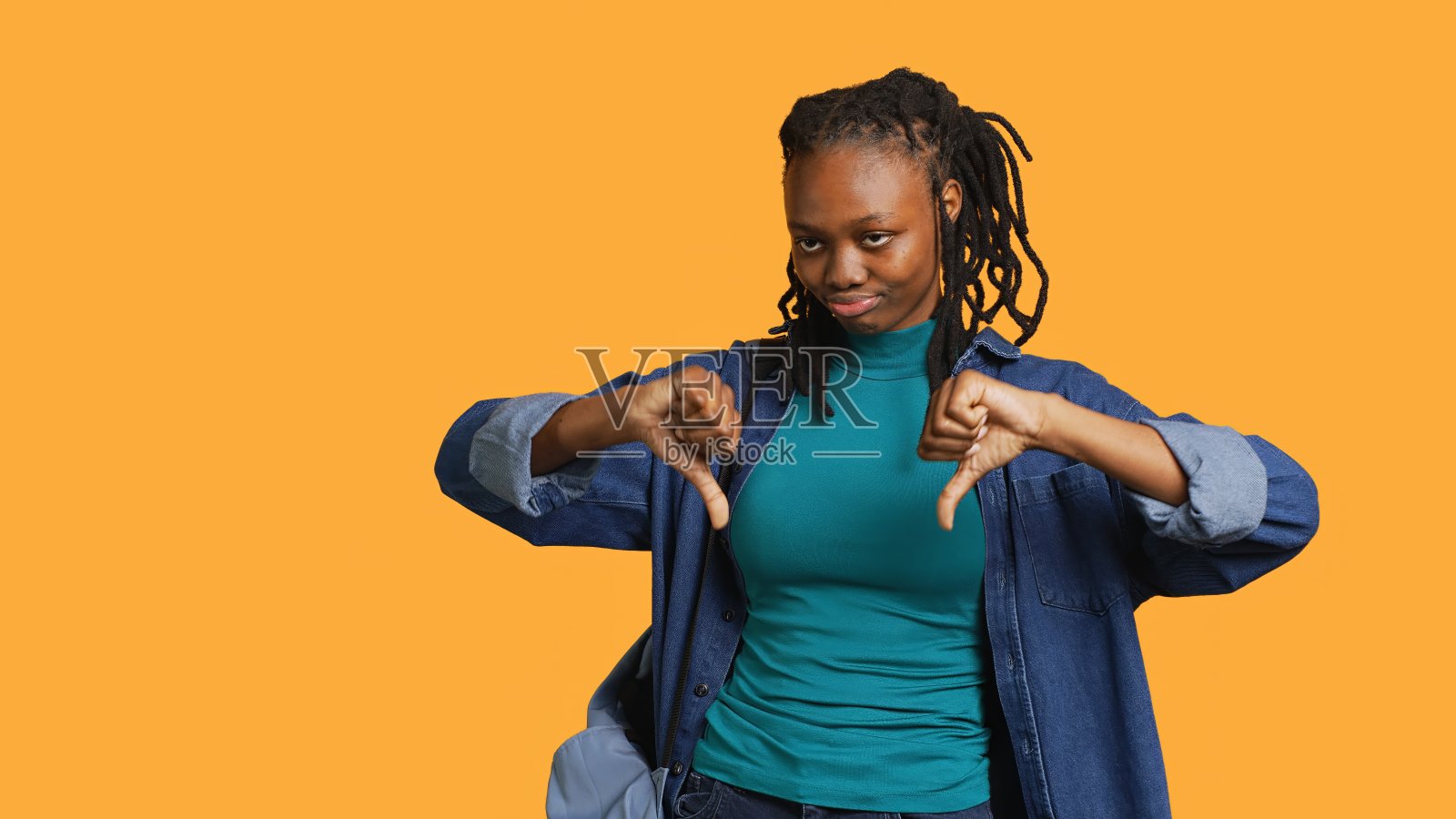 女孩做不喜欢的手势，工作室背景照片摄影图片