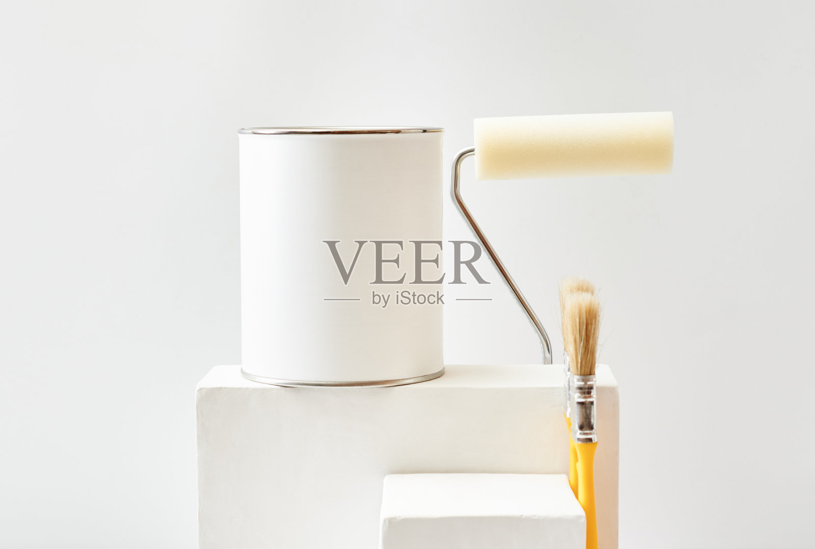 几何底座或底座用油漆罐、刷子、海绵滚筒在白色底色上涂布。模拟展示作品照片摄影图片