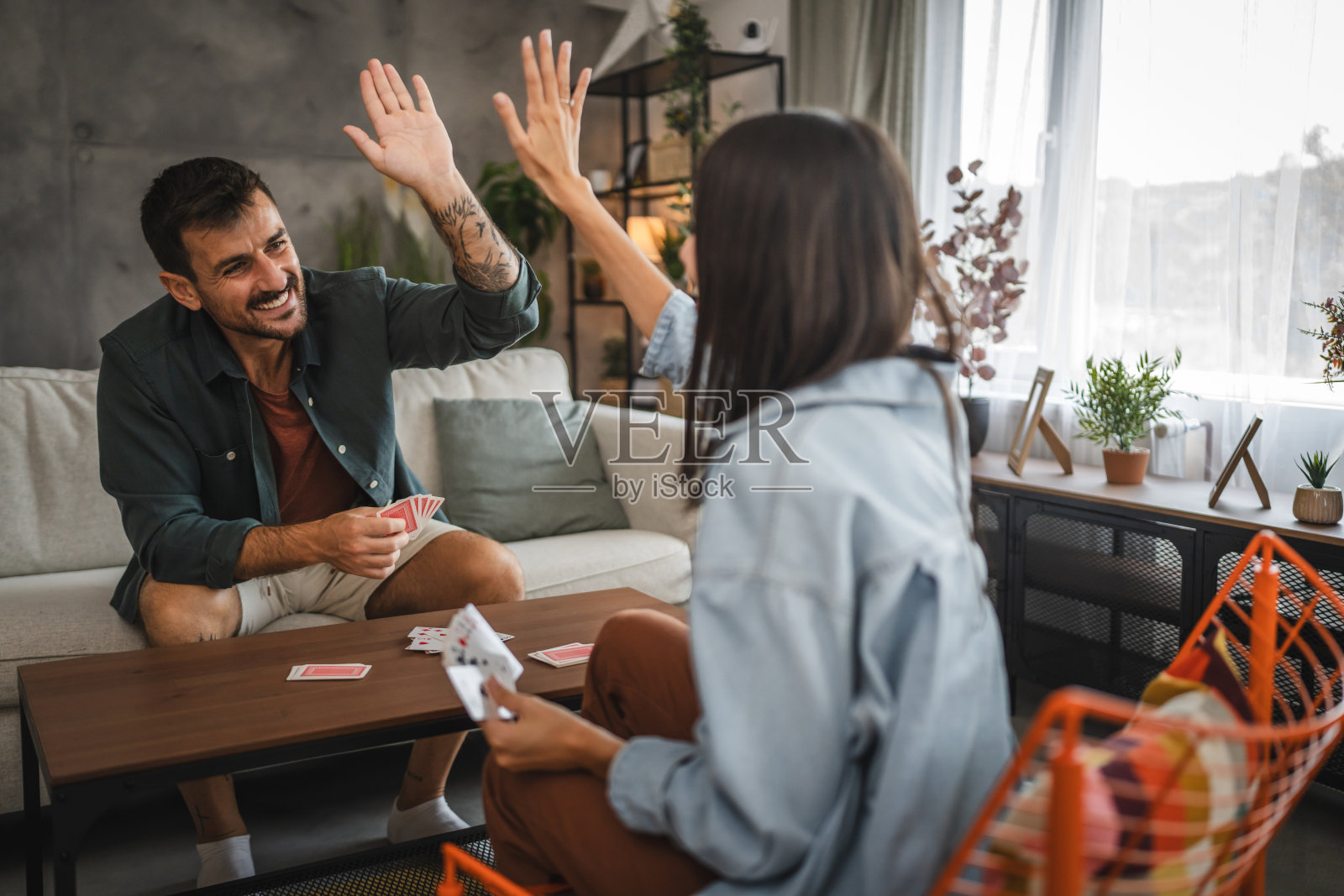 成年白人夫妇在家里成功打牌后击掌照片摄影图片