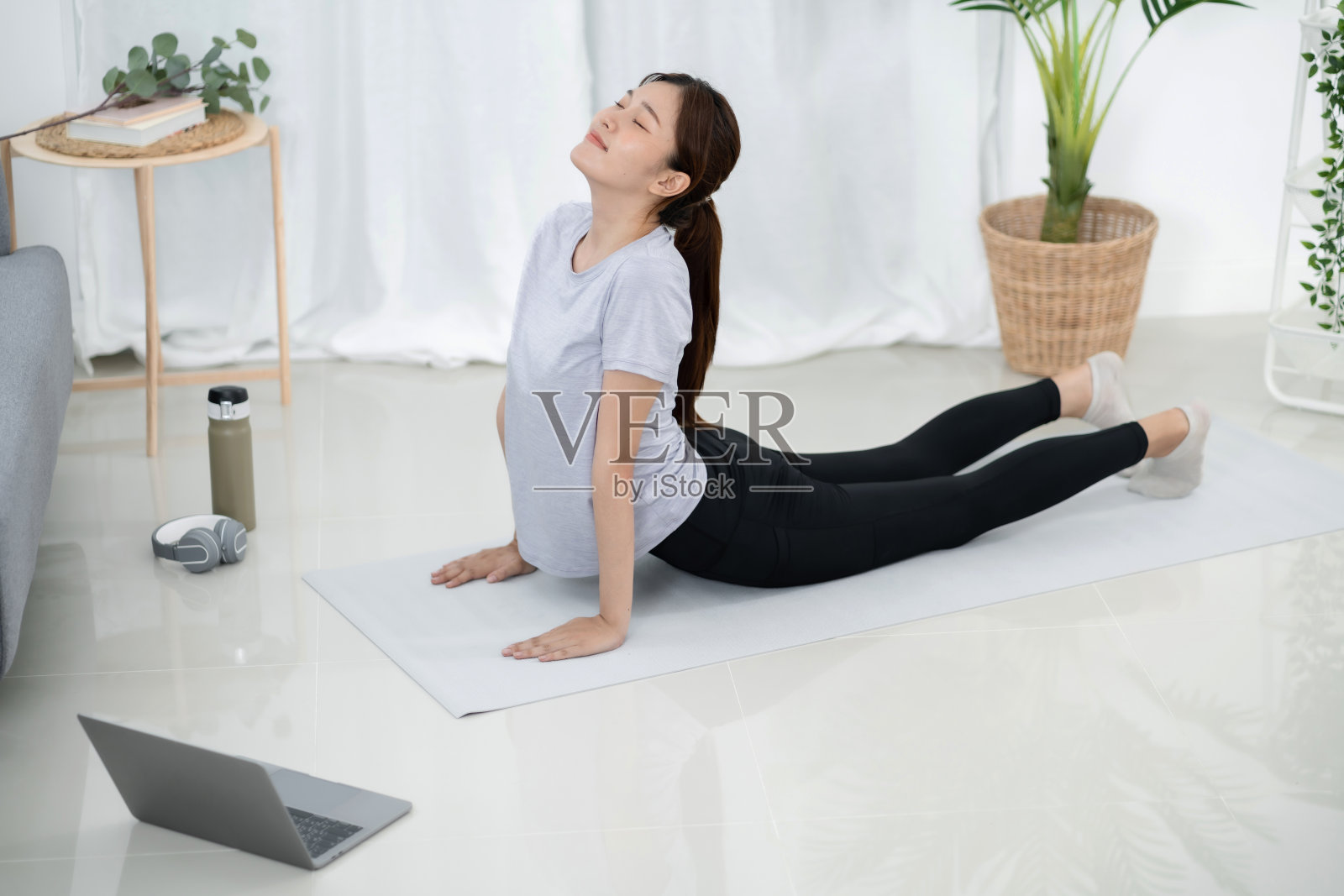 年轻的亚洲女性有吸引力的运动锻炼在家里和观看在线体育教程在笔记本电脑上照片摄影图片