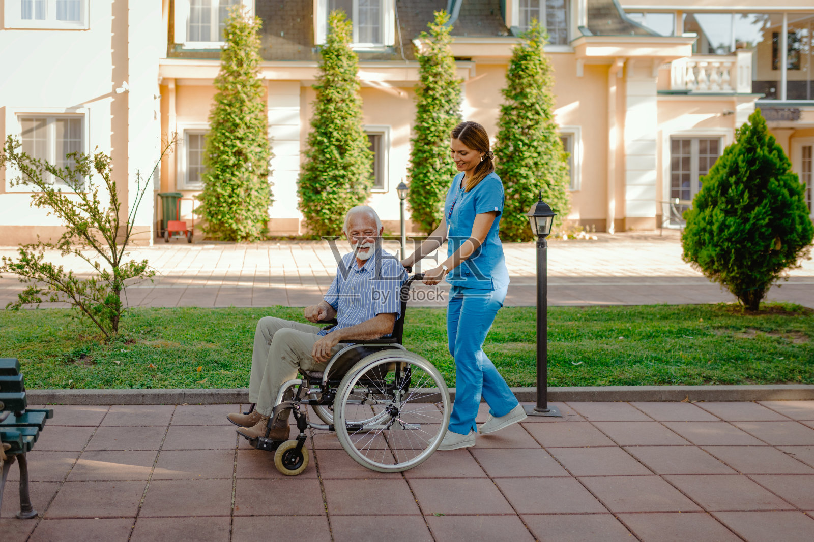 护士与轮椅上的病人在疗养院照片摄影图片