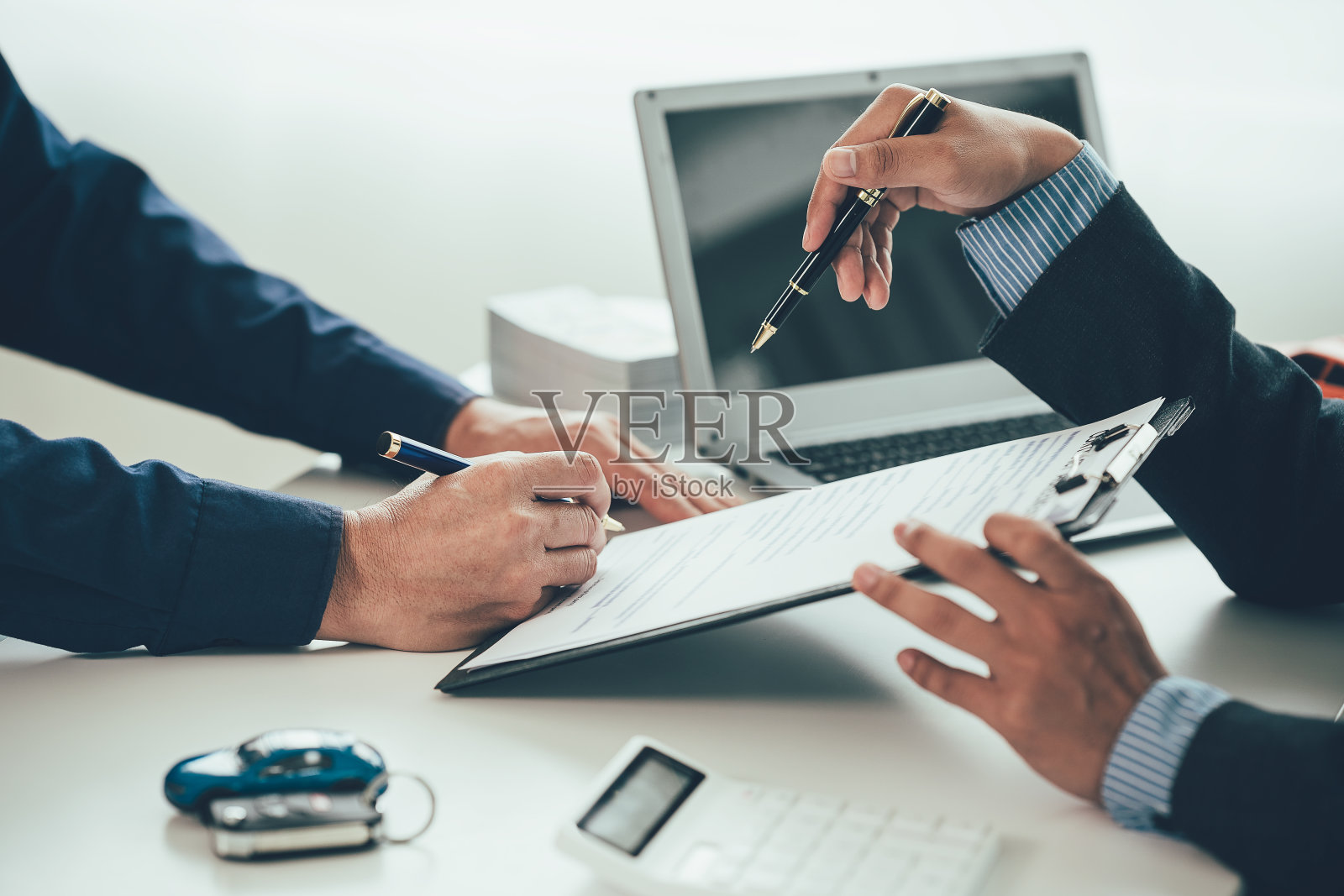 一个销售人员正在展示厅里向顾客推销低价产品。计算租用新电动汽车成本的特别推广活动。买方同意租赁一辆电动汽车。照片摄影图片