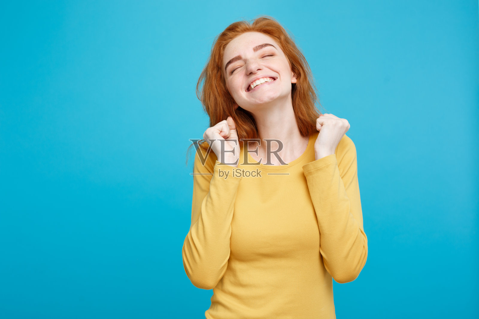 快乐的年轻女子站在蓝色背景下照片摄影图片