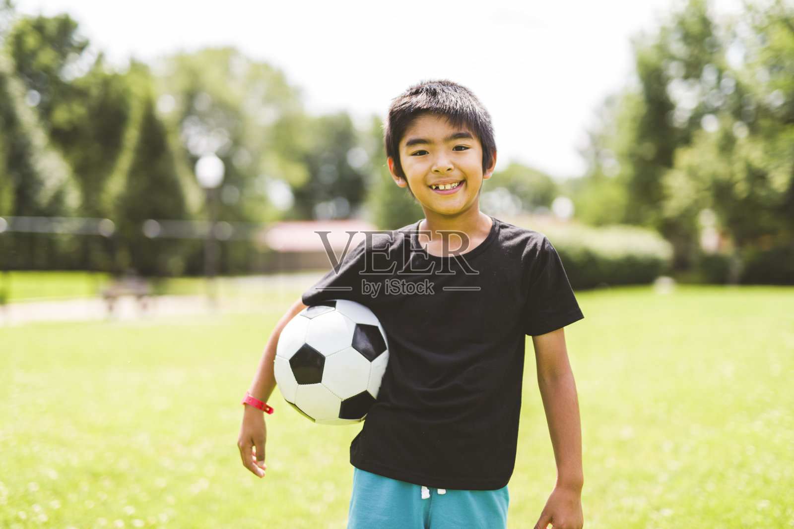 又好又帅的小男孩在外面踢足球照片摄影图片