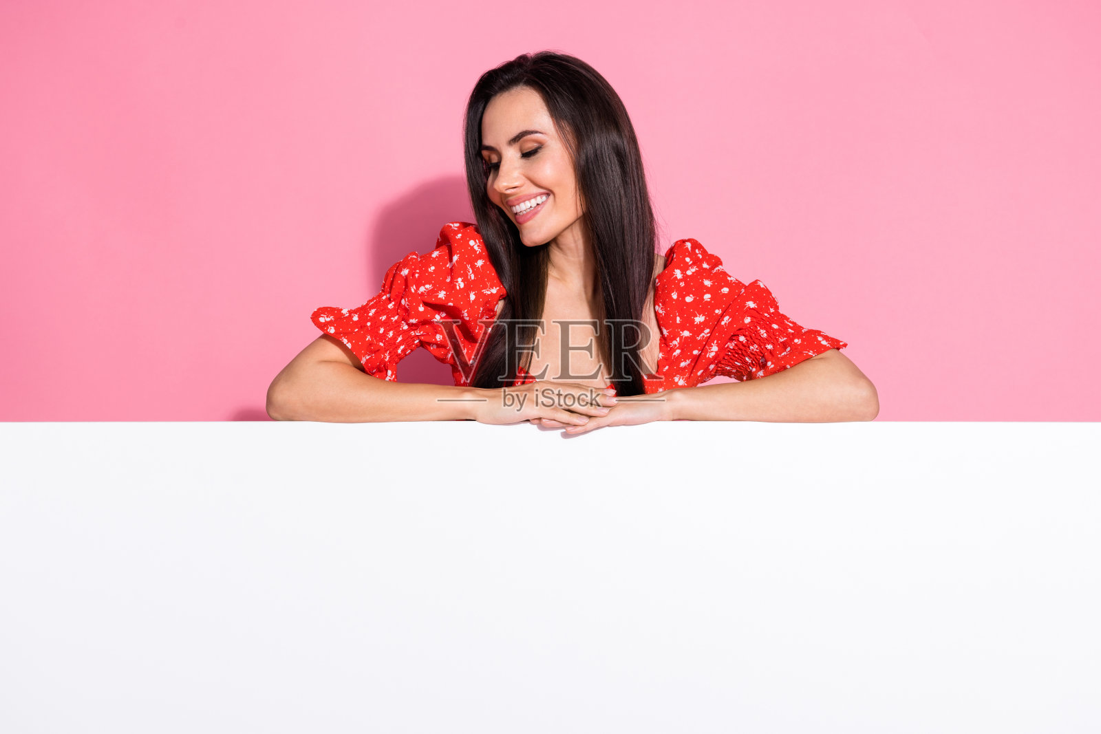 漂亮的年轻女子的照片看起来空白的空间，空白的穿着上衣孤立在粉红色的背景照片摄影图片