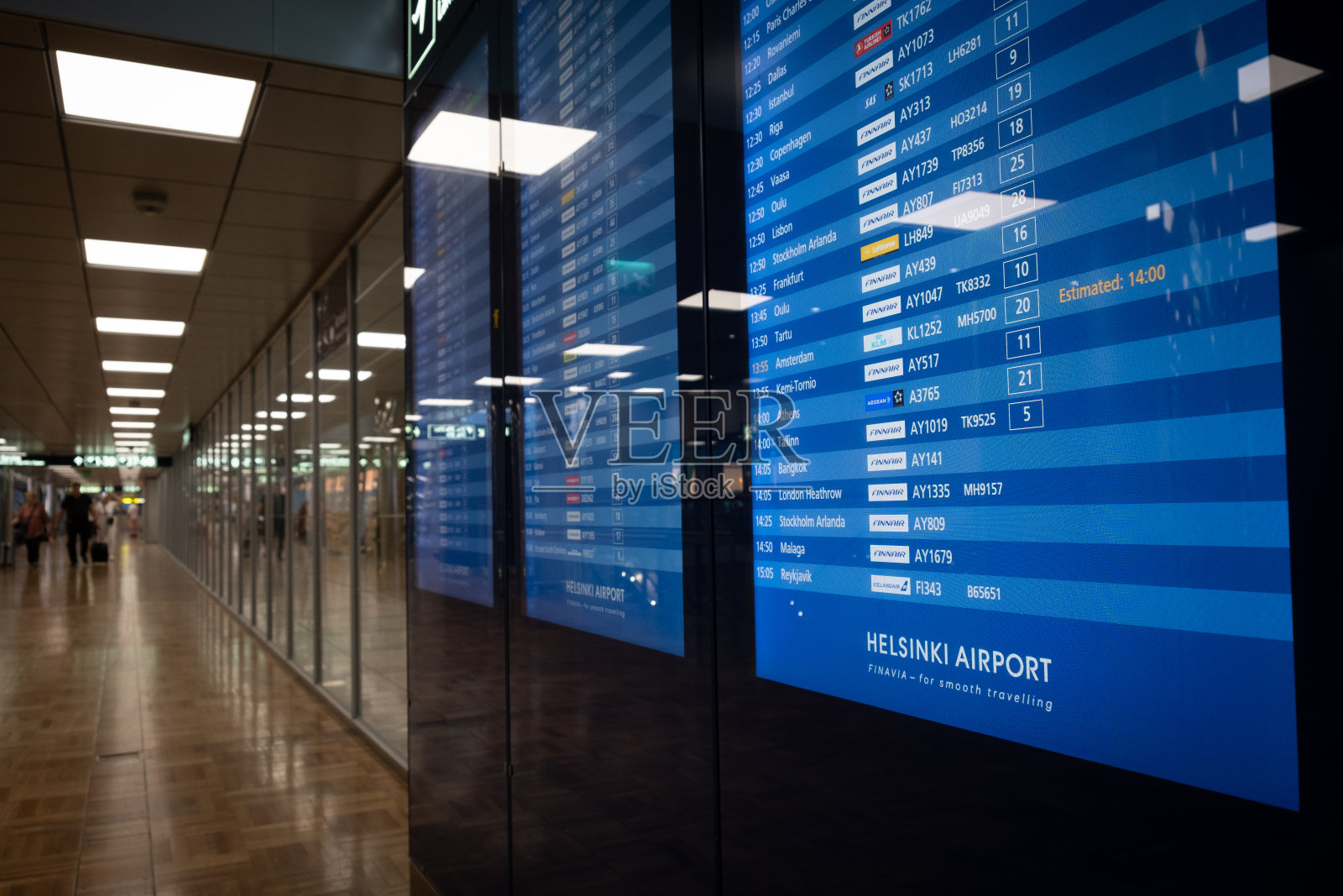 到达和离开航班的照明电子机场公告牌。照片摄影图片