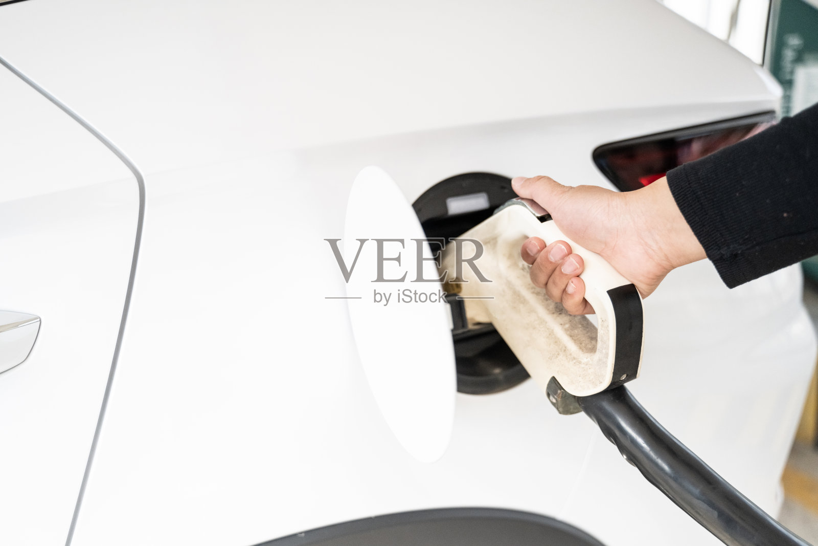 一个人正在高速公路服务区的电动汽车充电站充电照片摄影图片