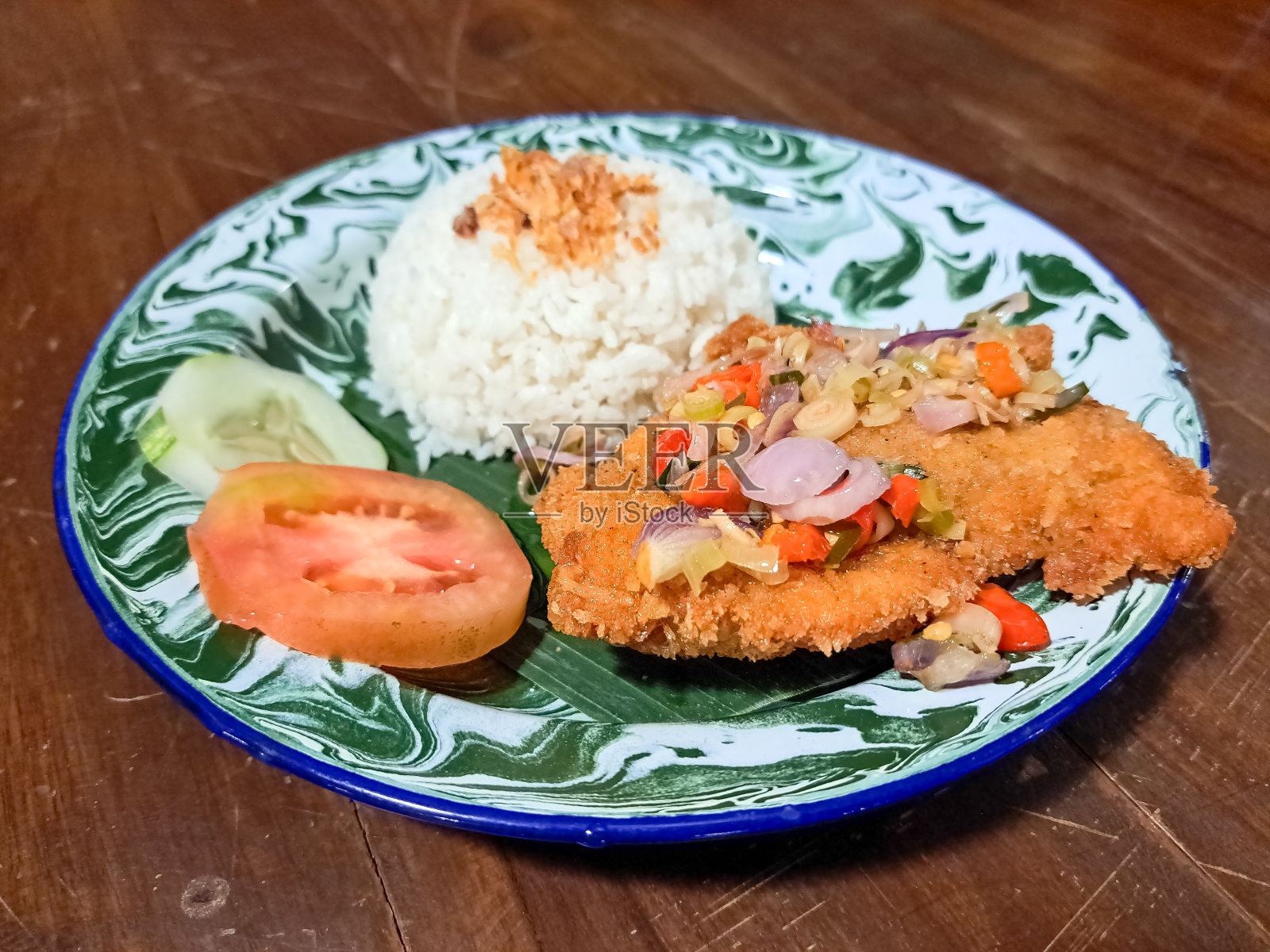 美味的纳西Ayam Katsu Sambal Matah或Matah辣椒鸡Katsu米饭与蔬菜。传统食物菜单。照片摄影图片