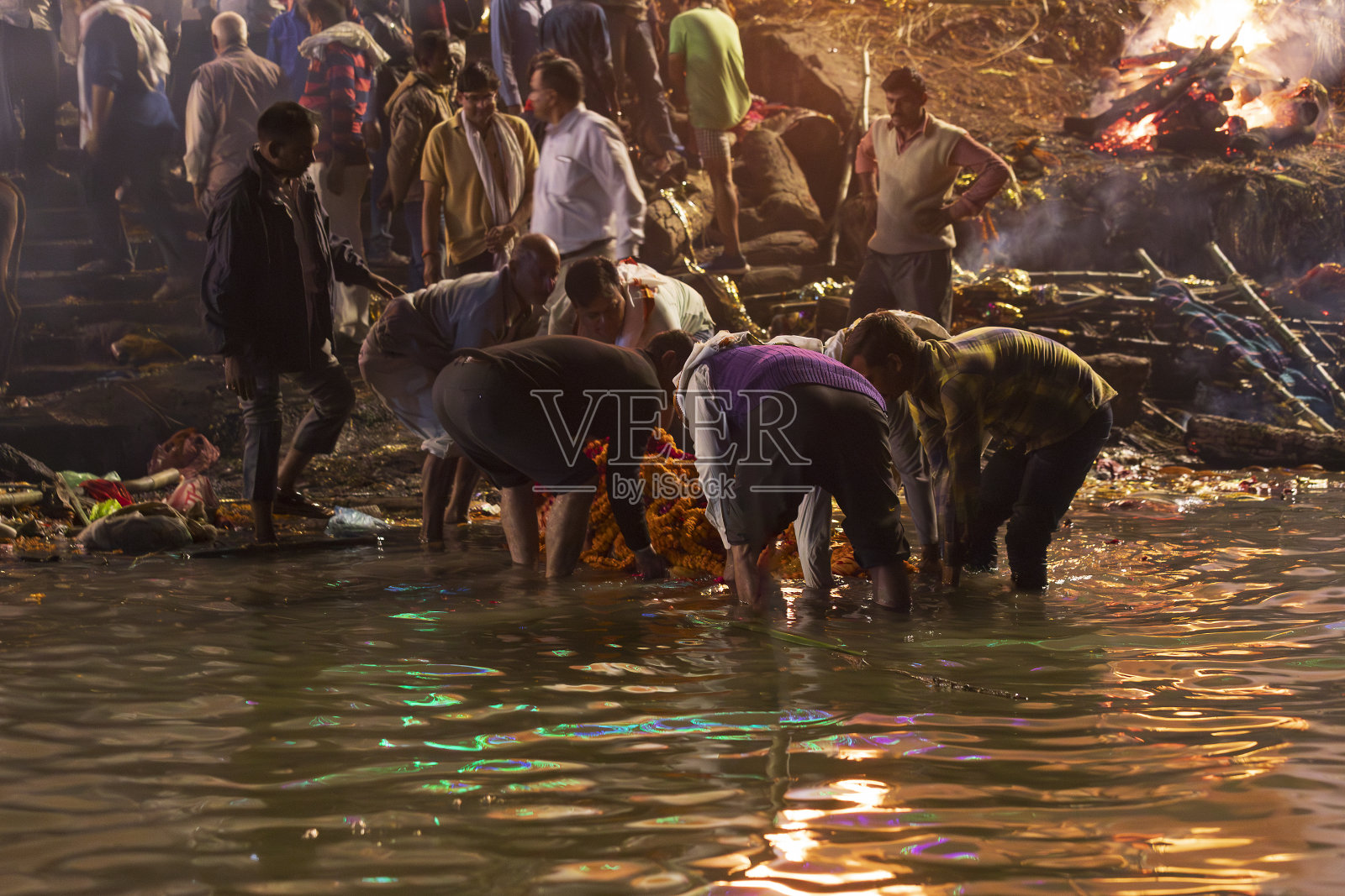 印度，北方邦，瓦拉纳西。人们在火化前把尸体带到恒河。照片摄影图片