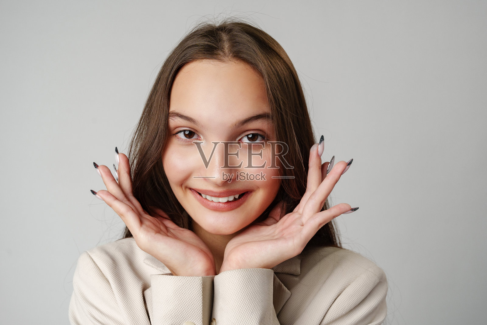 棕色头发的年轻女子在白色背景前看起来很惊讶照片摄影图片