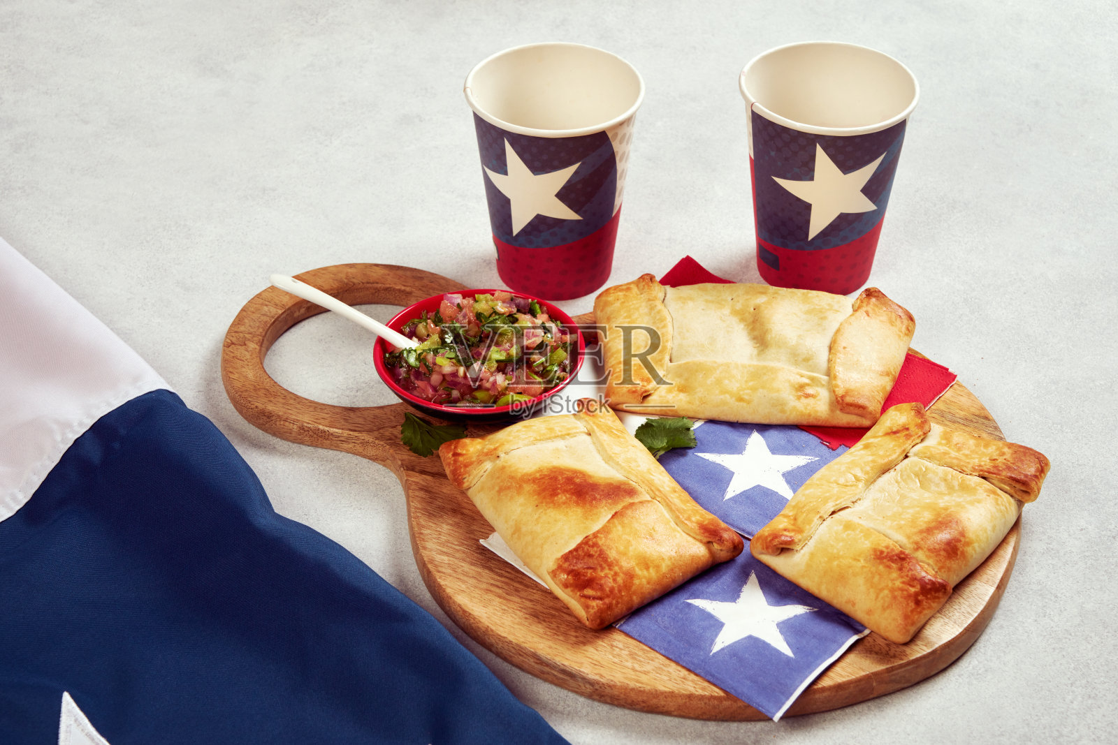 木质托盘上的智利肉馅卷饼和佩布里肉馅卷饼，玻璃杯上还有智利国旗照片摄影图片