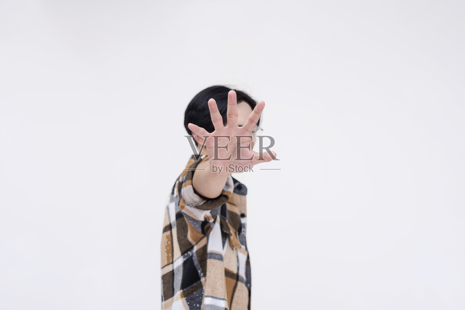 一个固执的年轻亚洲男子要求匿名。用手示意停止。孤立在白色背景上。照片摄影图片