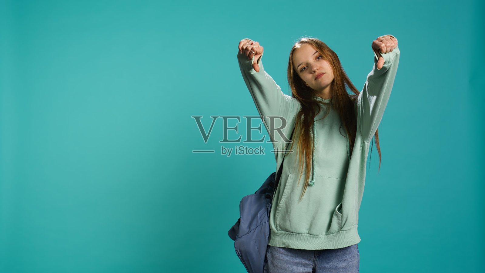 沮丧的女人在做拇指朝下的手势照片摄影图片