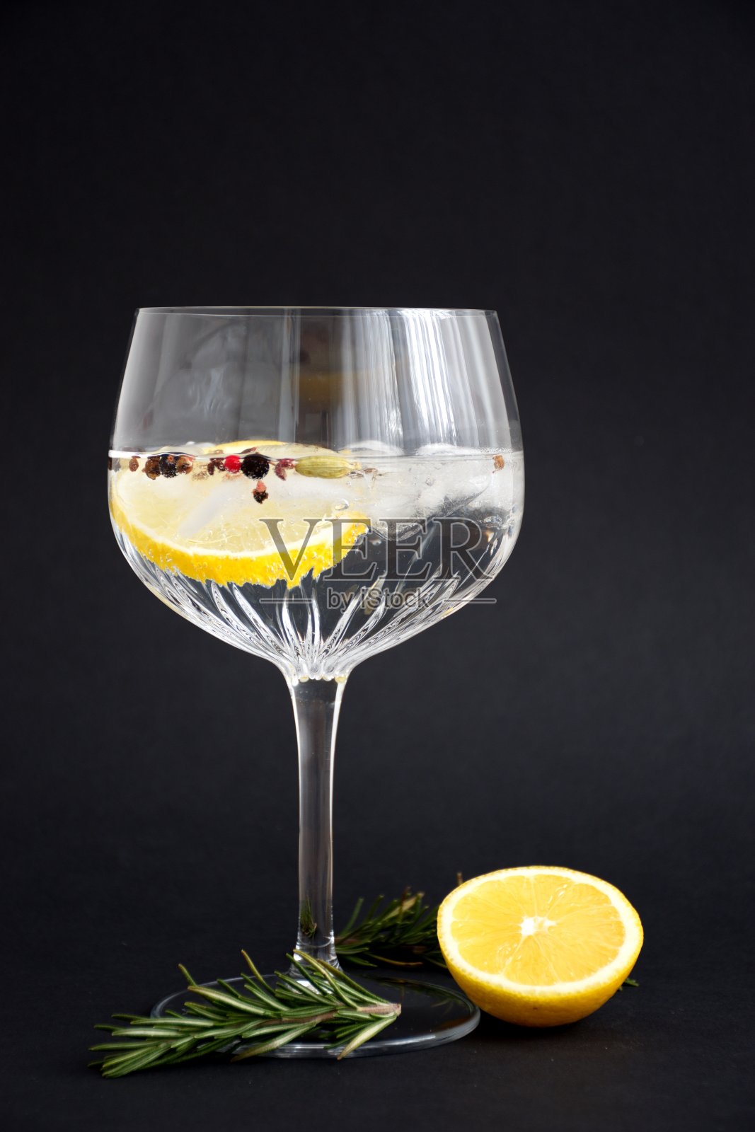杜松子酒和奎宁与柠檬和迷迭香在水晶玻璃对黑色背景照片摄影图片