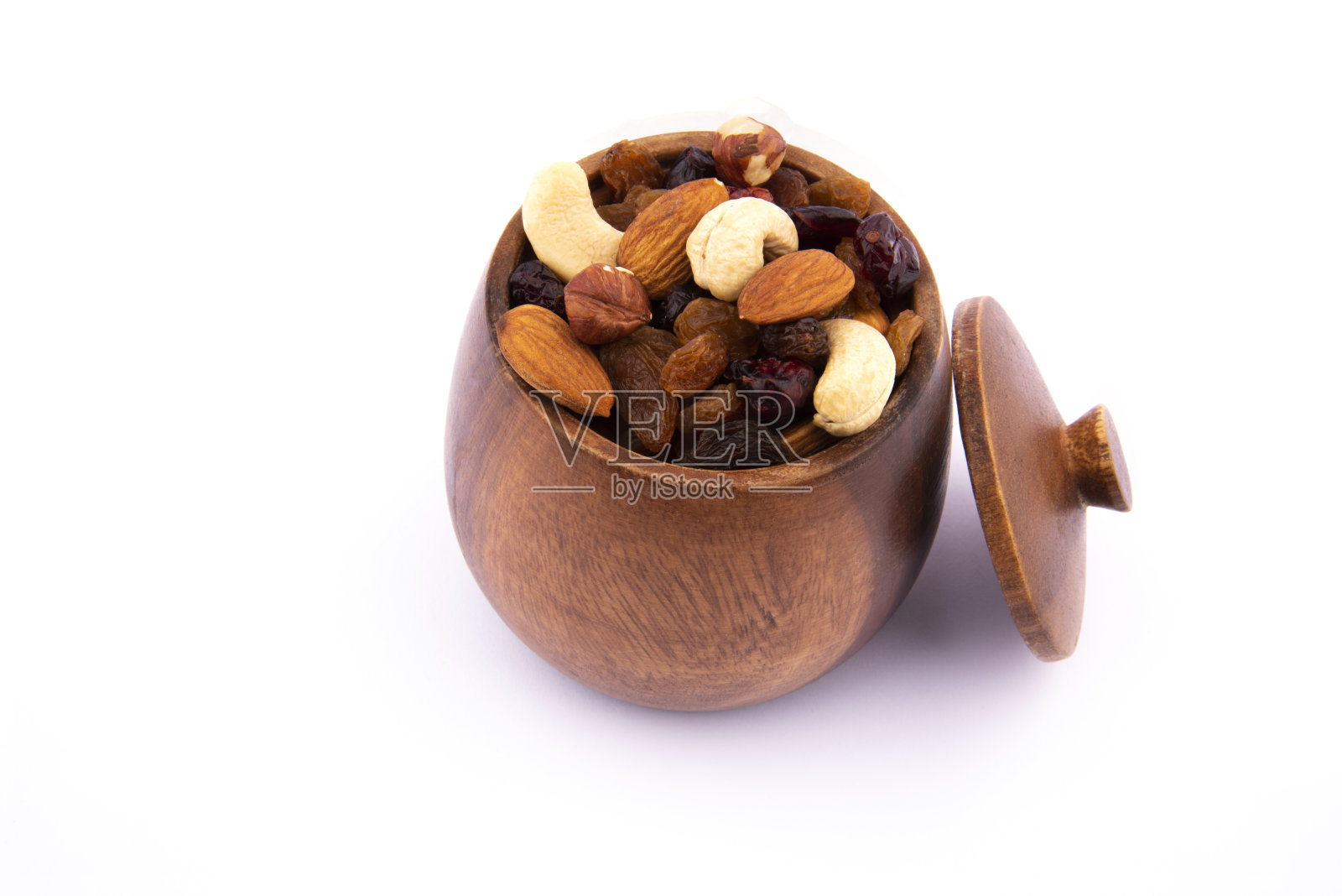生坚果装在有盖的木碗里。碗里的坚果，上面的照片照片摄影图片