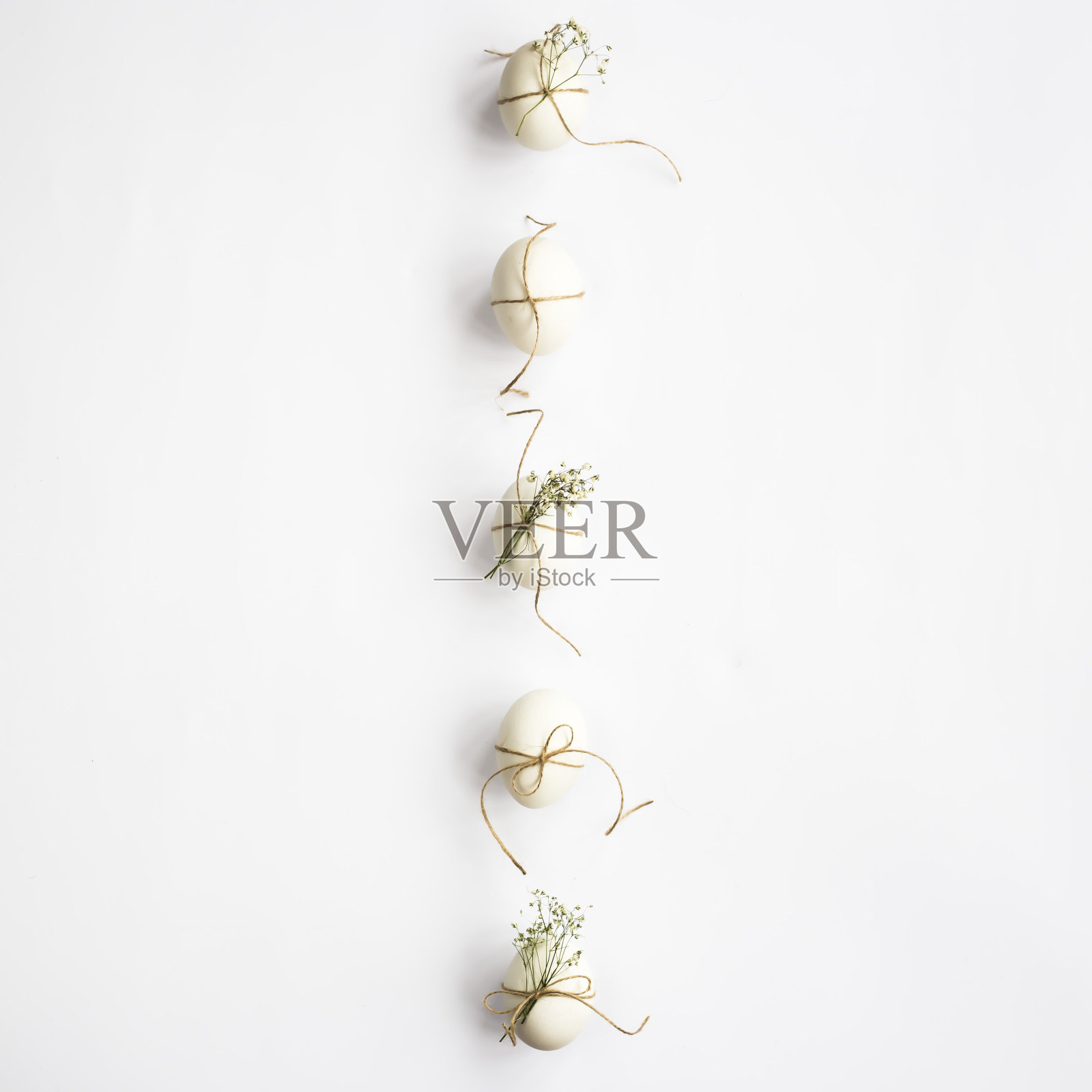 正上方的复活节彩蛋，在白色的背景上装饰着Gypsophila和麻绳照片摄影图片