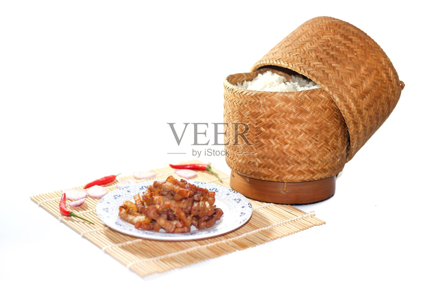 美味的泰国美食，糯米和炒猪肉，辣椒和洋葱切片，竹席上，风格独特。照片摄影图片