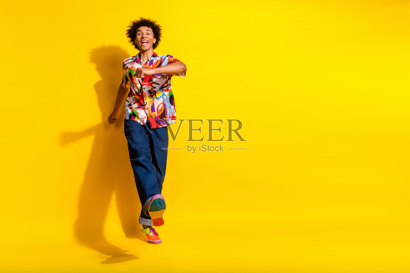 漂亮时髦的年轻人的全身肖像走路跳舞空的空间穿衬衫孤立在充满活力的黄色背景照片摄影图片