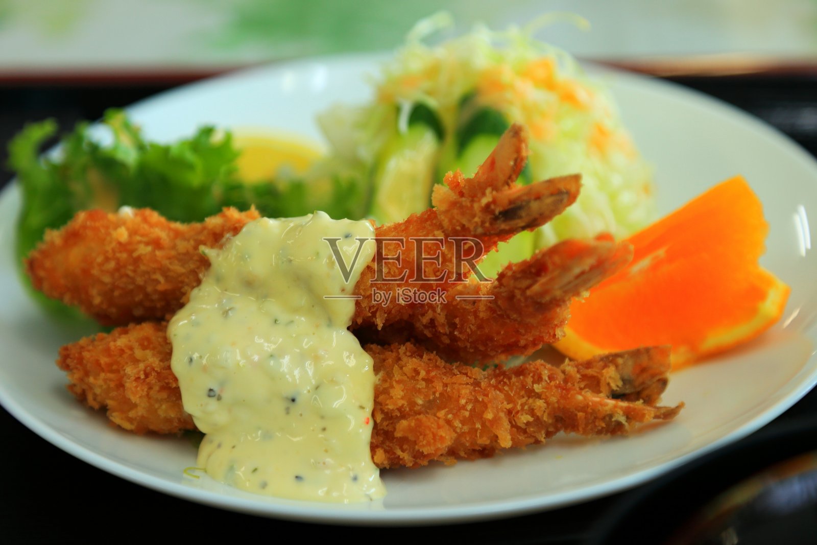 餐桌上盘子里的炸虾配沙拉的特写照片摄影图片