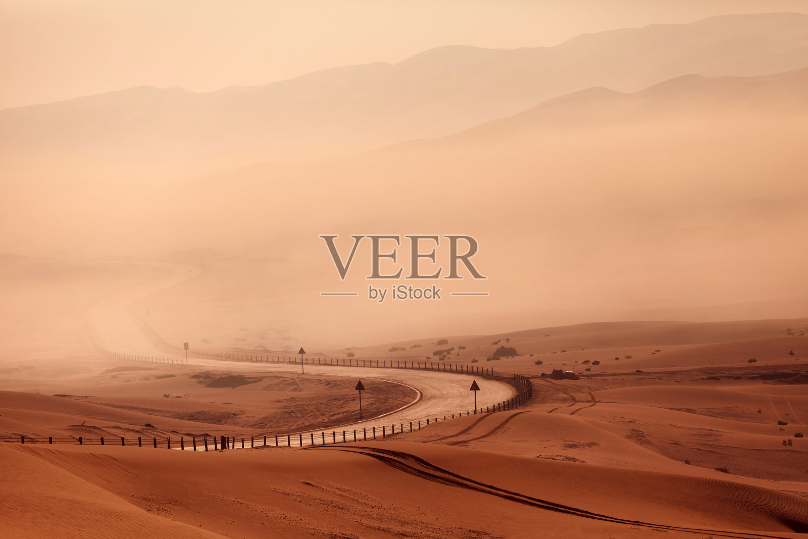 雾中沙漠里蜿蜒的空旷道路照片摄影图片