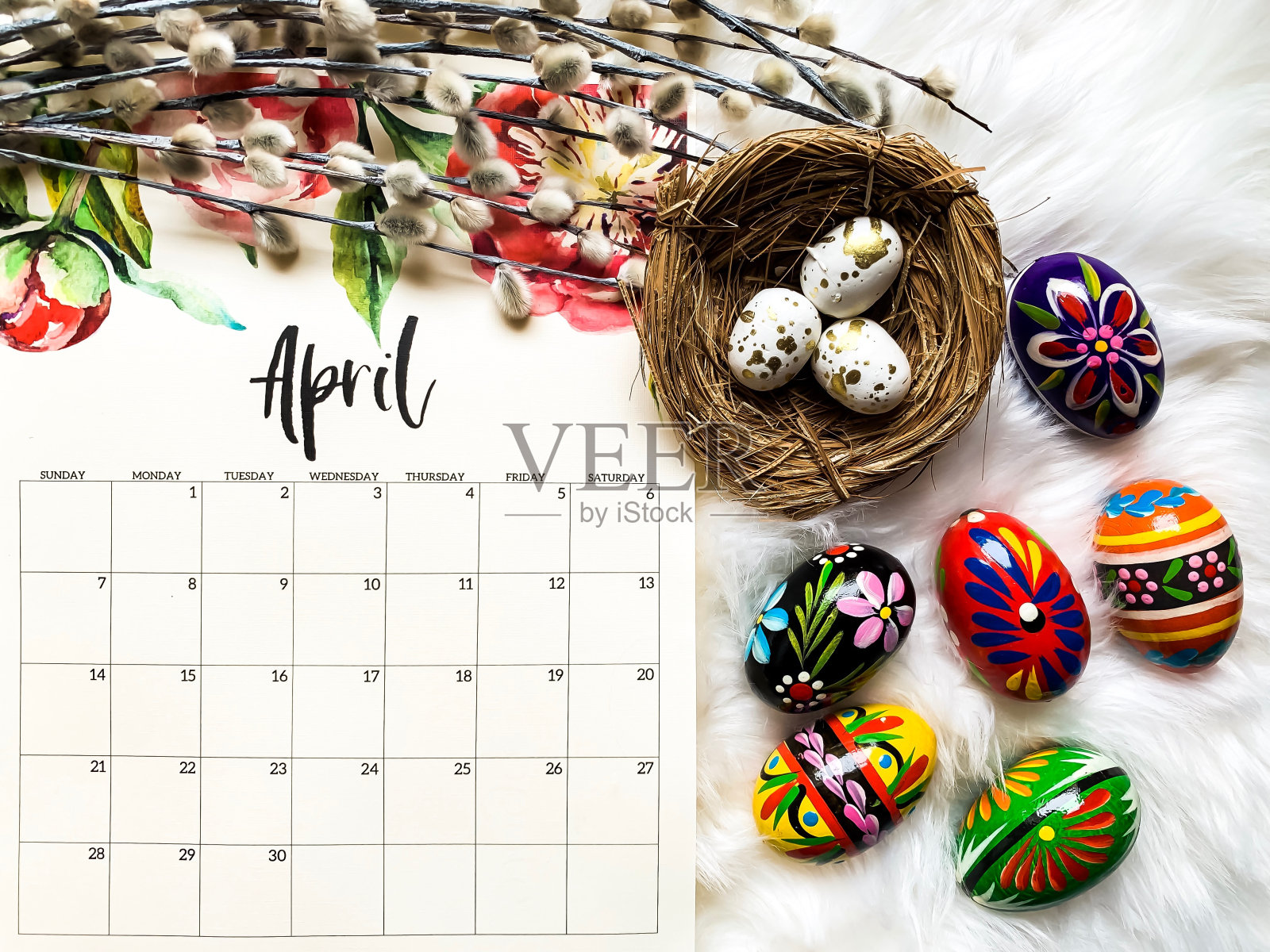 高角度的彩色复活节彩蛋与日历在桌子上照片摄影图片